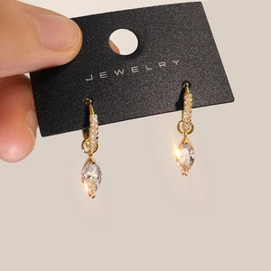 Close-up of gold marquise-cut zircon hoop earrings with sparkling pave-set micro stones