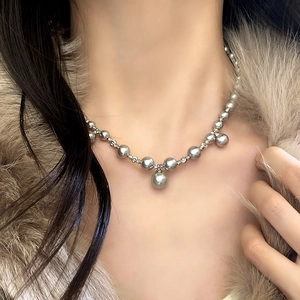 Collier élégant de perles gris foncé avec perle centrale porté par un mannequin en fourrure