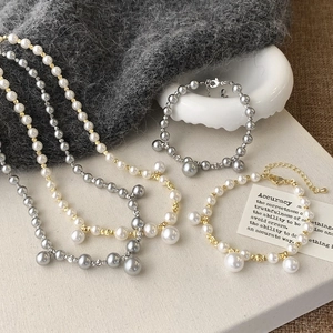Ensemble de colliers de perles élégants avec chaînes dorées et argentées sur fond gris