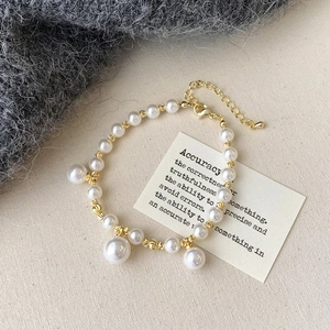 Vue détaillée du collier de perles et perles dorées sur fond de tissu élégant