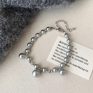 Détail du bracelet en perles grises avec perles argentées et fermoir mousqueton réglable