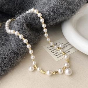 Vue détaillée d'un collier de perles françaises avec des perles dorées gravées