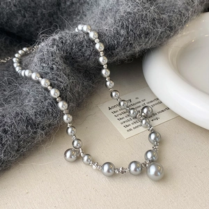 Détail du collier de perles gris dégradé avec entretoises argentées et fermoir mousqueton
