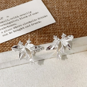 Detail of silver petal stud earrings with cubic zirconia butterfly wing design
