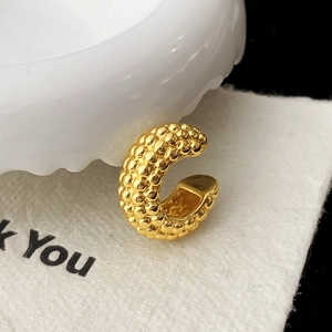 Vue détaillée d'une manchette d'oreille en C dorée avec surface texturée à perles