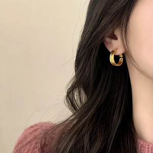 Minimalist multi-layered gold plated hoop earrings with textured finish on model