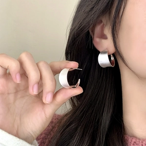 Minimalist silver brushed C-shape stud earrings with a matte textured metallic finish