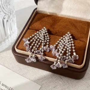 Detailed view of silver zircon tassel earrings featuring five beaded chains in a velvet box
