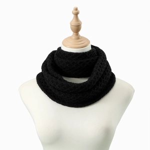 Detail shot of black chunky knit infinity scarf texture on a mannequin bust