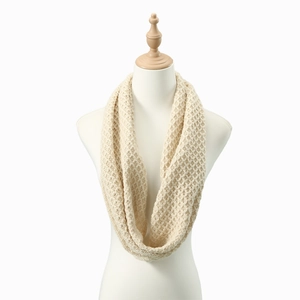 Detail of chunky cable knit snood in cream white with a hollow crochet texture