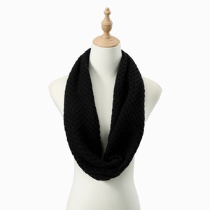 Detailed honeycomb knit texture of a black infinity scarf on a white model stand