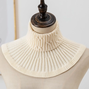 Detail van kabelpatroon en ribstructuur op de warme gebreide colkraag in de kleur crème