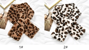 Detail of leopard print faux fur scarves with thick plush texture and crossover design