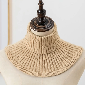 Detail van beige kabelgebreide col met zachte garentextuur gepresenteerd op een mannequin