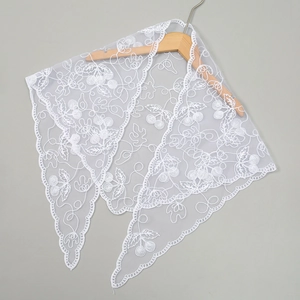 Detail of white lace triangle scarf featuring cherry embroidery and scalloped edges