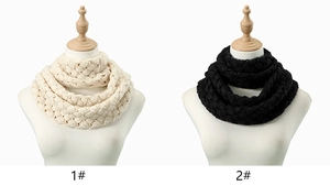 Detail of chunky knit neck warmer featuring cable knit texture in cream and black colors