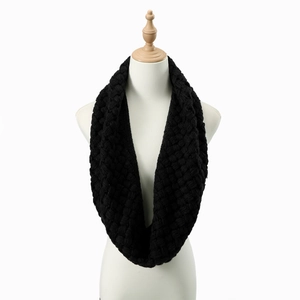 Nahaufnahme eines kuscheligen schwarzen Strickschals, stilvoll präsentiert an einer Büste.