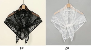 Détail de la broderie sur l'écharpe triangle en dentelle avec motifs floraux et festonnés