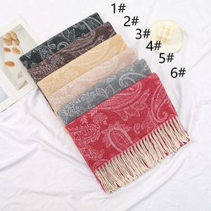 Flat lay of cashmere-feel paisley scarves with tassels in six elegant colors