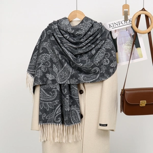Detail of dark grey paisley scarf with fringe hem over a beige handmade wool coat