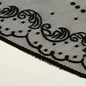 Gros plan détaillé de broderies complexes en dentelle noire aux motifs floraux
