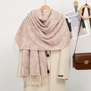 Detail of beige paisley pashmina shawl with fringes styled on a wool handmade coat