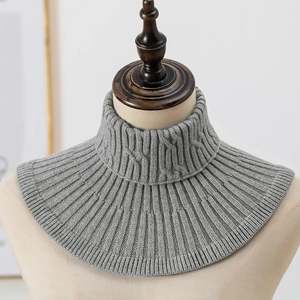 Detail van grijze kabelgebreide kol met zachte ribstructuur en warm gebreid materiaal