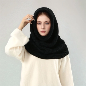 Detail eines dicken schwarzen Strickschals mit Kapuze auf einem Modell mit feiner Struktur
