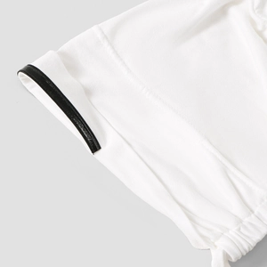 Primo piano del bordo di un berretto bianco da donna con finiture nere e coulisse elastica.