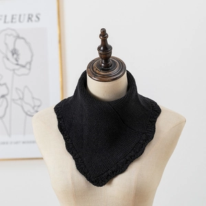 Détail du cache-col en tricot noir avec bords festonnés et texture côtelée fine