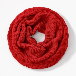 Nahaufnahme des dicken roten Strickschals mit detaillierter Zopfmuster-Textur