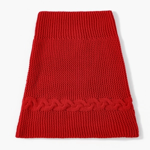 Nahaufnahme eines roten Grobstrick-Halswärmers mit einem eleganten Zopfmuster-Detail
