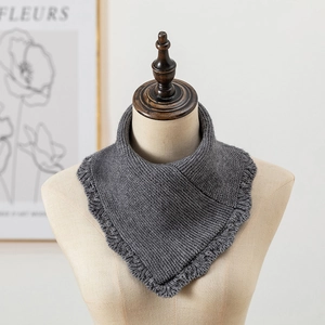 Détail d'un cache-col en tricot gris avec bords à volants et texture gaufrée