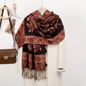 Scialle etnico con motivo paisley e frange su cappotto bianco per uno stile invernale