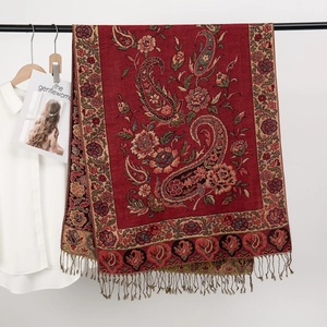 Dettaglio di sciarpa jacquard rossa con motivo paisley e frange in esposizione