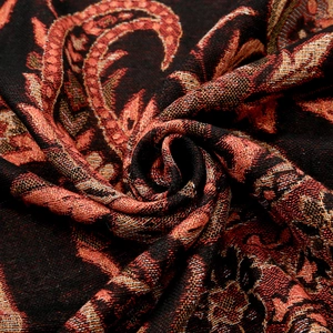 Dettaglio dello scialle jacquard paisley con motivi rossi e trama in tessuto morbido