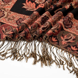 Dettaglio del tessuto jacquard paisley rosso e oro con nappe annodate a mano