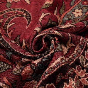 Dettaglio ravvicinato del tessuto jacquard paisley rosso e oro di alta qualità con frange