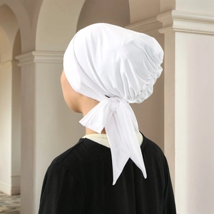 Elegant white pleated Muslim hijab cap with adjustable bow tie strap in minimalist style