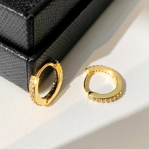 Detail of gold hoop earrings featuring micro-paved cubic zirconia in a jewelry box