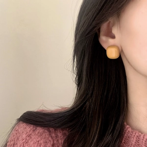 Minimalist yellow square resin stud earrings worn by model for daily fashion look