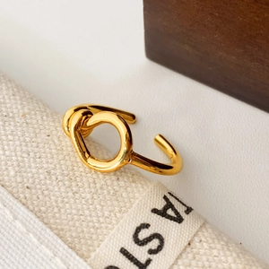 Minimalist 18K gold plated knot ring with adjustable open design on canvas background