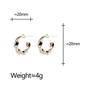 Détail des boucles d'oreilles dorées torsadées en C de 20mm avec finition polie
