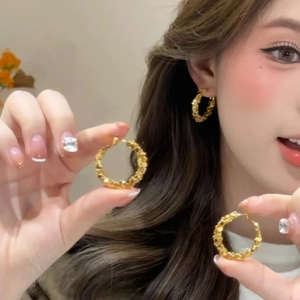 Modern gold hoop earrings with irregular hammered texture on model with multiple views