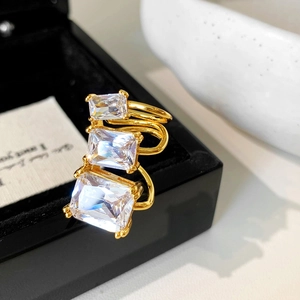 Detail of gold triple-layered ring featuring three graduated rectangular emerald-cut zircons