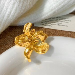 Detailed close-up of gold-plated flower ring showing fine brushed metal texture