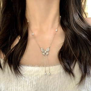Elegante collana a farfalla argentata con ali di zircone e accenti di nappe di perle