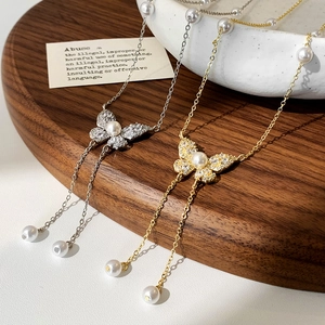 Elegante collana a farfalla con perle e nappe in oro e argento con accenti di cristallo