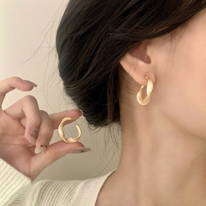 French vintage gold twisted earrings on model with elegant minimalist Mobius C-shape design