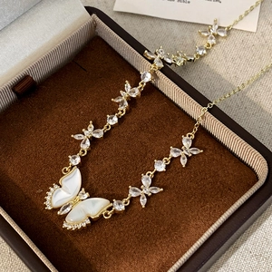 Vue rapprochée du collier papillon doré avec nacre dans son coffret à bijoux luxe